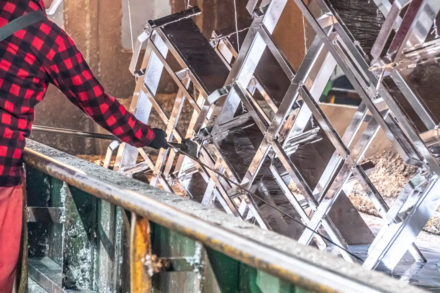 zdjęcie mężczyzny wyciągającego element z galwanizacji w zakładzie Strumet